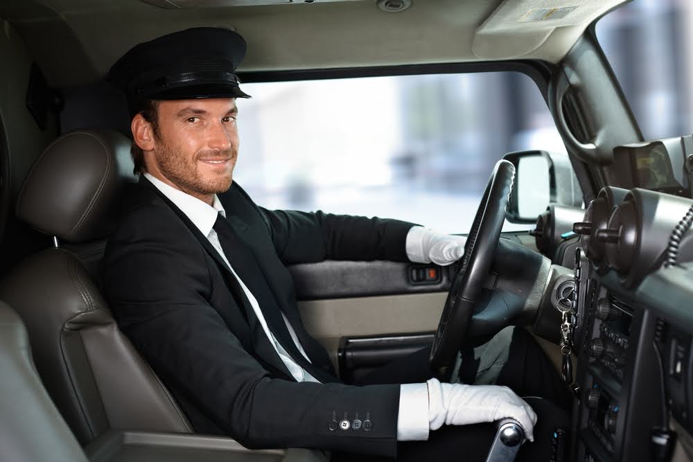 Smiling Chauffeur Driving a Limo