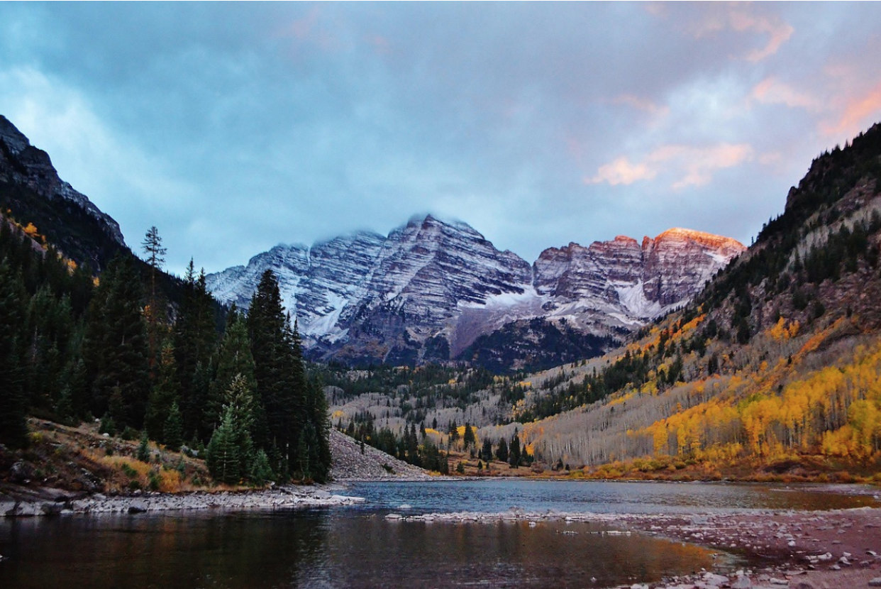 Mountain peaks and forest reflecting in a lake.
